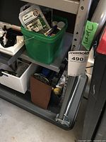 Photo showing the metal flatbed rolling cart with a partial view of the fold-down handle and wheels.