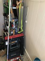 Overview of storage corner showing sawhorses, toolboxes, and various hand tools hung or stored