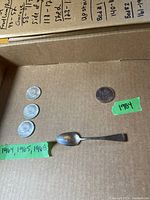 Three US Kennedy half dollars (1964, 1965, 1968), Canadian silver dollar (1984), and silver coffee spoon with hallmarks