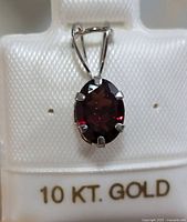 Front view of the 10KT gold garnet pendant with visible prong setting and garnet stone color.