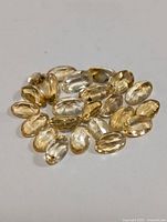 Photo showing a group of oval faceted citrine gemstones with light yellow to golden colors, total approx 4ct.
