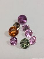 Loose assorted fancy color sapphires in various colors and cuts on white background