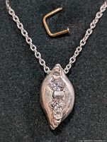 Front view of the sterling silver necklace pendant with three cubic zirconia stones on a black background.