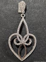 Front view of the sterling silver pendant showing detailed cubic zirconia in intricate openwork design and polished silver teardrop-shaped loop
