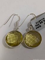 Silver lemon quartz earrings shown from front and angled views, highlighting faceted oval stones and silver setting.