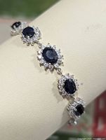 Close-up photo showing the linked oval sapphire stones surrounded by cubic zirconia on sterling silver bracelet.