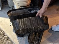 Five dark brown plastic wicker-style flower baskets stacked showing the weave and size.