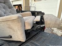 Side view of beige cloth recliner chair showing footrest extended and reclining mechanism.