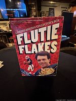 Front view of large rectangular red cereal box for Limited Edition Flutie Flakes featuring Doug Flutie and football imagery.