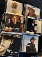 Photo of assorted country music CDs including Shania Twain, Keith Urban, Tim McGraw, and others.