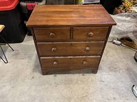 Wooden end table front view showing four drawers and wood surface