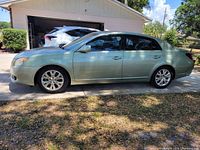Left side profile of green Avalon parked on driveway