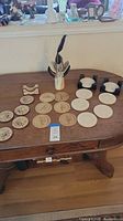 Photo of table displaying assortment of coaster sets arranged with holders and decorative items