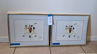 Pair of framed Disney serigraphs titled Mickey's Polo Team showing Mickey riding a polo horse, with brass tone frames, positioned side by side.