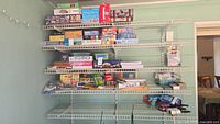 Full view of shelves stocked with puzzles stacked horizontally and vertically, board games of various sizes, and office supplies organized below.