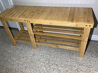 Front view of wood hall bench showing slatted top and two open slatted shelves below