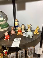 Eight ceramic figurines arranged on shelf, front view