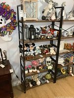 Front view of the metal frame bookshelf fully assembled with wooden shelves. Decorative items such as plush toys, lanterns, and flower pots visible but not included in sale.