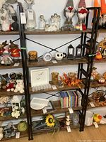 Full front view of the metal frame bookshelf filled with various decorative items showing shelf structure and shelving levels.