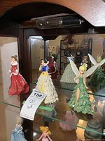 Three Bradford Exchange Disney character resin figurines displayed on glass shelf: Snow White, Tinker Bell, and a red dress character. Approx 5.5 inches tall each.
