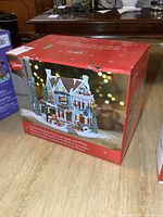 Original red retail box showing front artwork of the animated holiday house and Disney logo