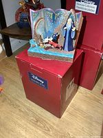 Photo showing full view of the Disney Fantasia figurine on top of original Disney Showcase Collection box with red color.