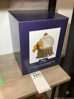 Closed original box of Disney Showcase Winnie the Pooh 100mm Musical Water Globe with product image and description.