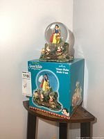 Water globe on its original box showing front view with Snow White inside the globe and seven dwarfs on the base.