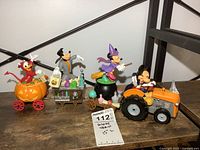 Overall view of the 4-piece Disney Halloween train set arranged on a wooden surface showing all characters and train pieces in sequence.