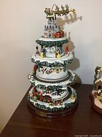 Full view of three-tiered Disney Christmas tree carousel with trains, rotating figures, castle topper and Mickey sleigh
