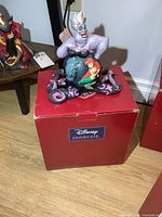 Disney Showcase Collection Ursula figure with eels on original red box, front view showing character details.