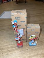 Overview of both Dr. Seuss figurines standing with their original boxes in the background.