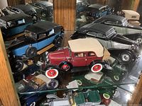 Photo of three Franklin Mint die cast model cars including red convertible, blue and black car, and black convertible