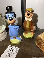 Both Huckleberry Hound and Yogi Bear porcelain figures displayed together on shelf