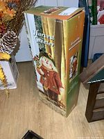 Full view of the Harvest Greeter figurine's original box with an image of the figurine printed on it.