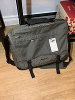 Green Eddie Bauer laptop bag front view showing padding, buckles, and handle.