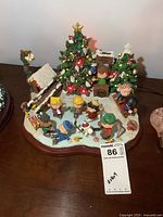 Front view of full lighted holiday skating scene on wooden base