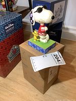 Full view of Jim Shore Peanuts Snoopy and Woodstock figure standing on original box, showing size and packaging.