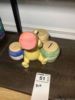 Front view of porcelain Winnie the Pooh piggy bank with four coin sections in different colors