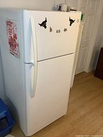 White Kenmore refrigerator with top freezer and removable decals on freezer door and sides