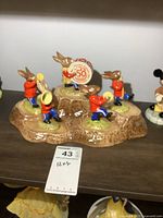 Overall view of Royal Doulton Bunnykins display with 5 bunny figurines each holding a musical instrument surrounding a central bunny holding a Golden Jubilee drum.