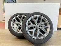 Set of 4 used alloy wheels stacked with attached tires, showing overall condition and quantity