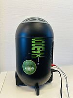 Black cylindrical Altec Lansing A300 subwoofer with green lettering, showing some wear marks, connected via cables and standing upright on feet.