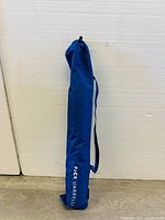 Folded umbrella in blue carrying bag labeled 'PACK UMBRELLA'