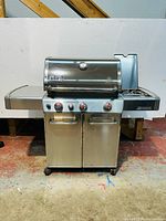 Front view of closed grill showing overall body, shelves and cabinet.