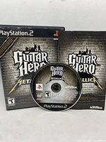 Original game disc for Guitar Hero Metallica for PlayStation 2 with branding and rating.