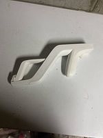 White plastic Nintendo Wii Zapper gun shell top view on white surface.