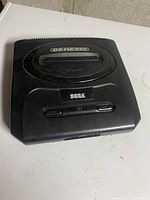 Front top angle shot of the Sega Genesis console showing the cartridge slot and button panel.