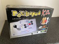 Front view of Psychopad K.O. 10-in-1 arcade stick box showing the product image and branding.