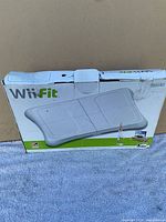 Front and top views of the Nintendo Wii Fit balance board original box showing some wear and tear.